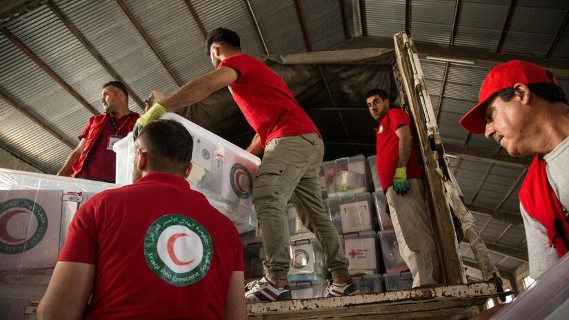Des matelas, des couvertures et des articles non alimentaires sont chargés dans un camion à Erbil par des volontaires du Croissant-Rouge irakien pour être transportés à Mossoul.