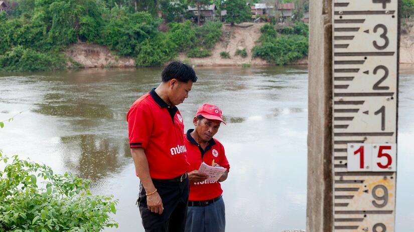 Los miembros de una Unidad de Protección ante Desastres de una aldea en la provincia de Khammouane, Laos, inspeccionan un medidor de línea de inundación durante una simulación de desastre probando su preparación