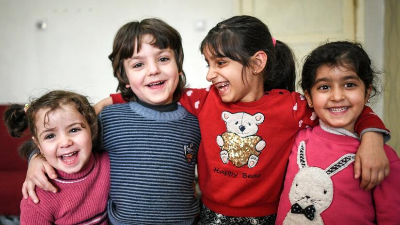 Four young Syrian girls smile and laugh together in their new home in Turkey. Their family moved to the country in 2018 due to the ongoing civil war in Syria, and they receive monthly cash assistance as part of the Emergency Social Safety Net programme run by the IFRC and Turkish Red Crescent and funded by the European Union.
