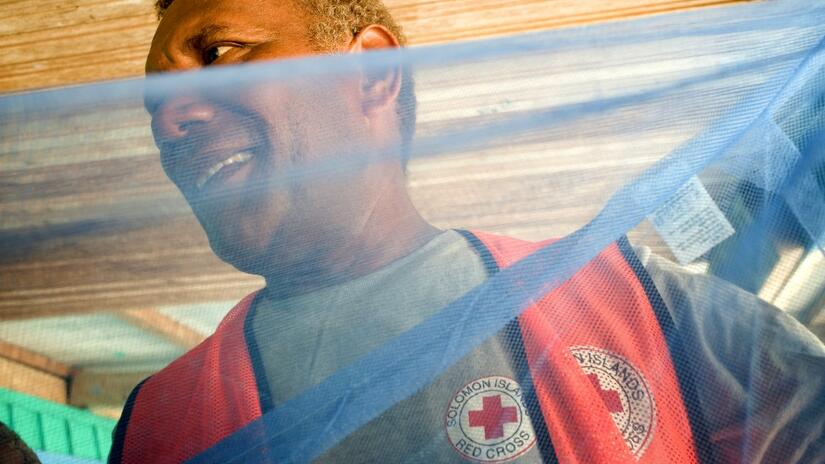 A Solomon Islands Red Cross volunteer helps distribute bed nets to communities in preparation for malaria season
