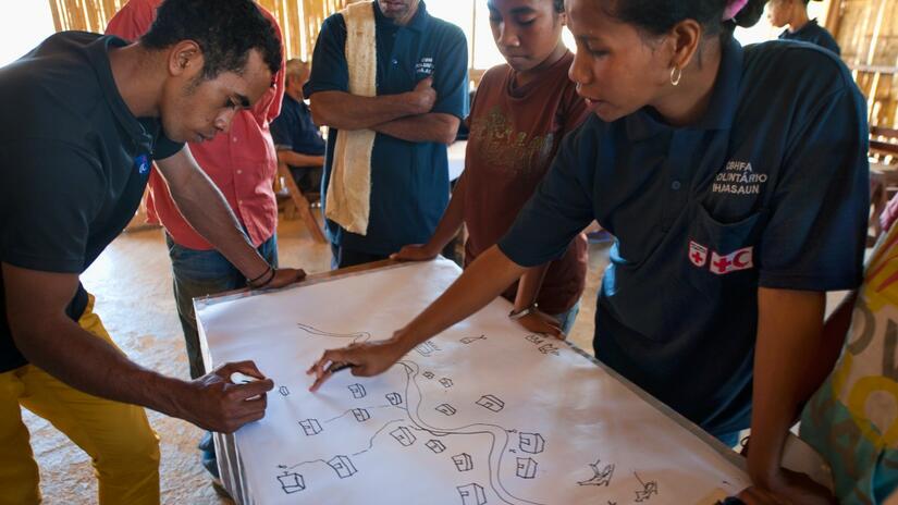 Voluntarios de la Cruz Roja en Timor-Leste realizan un ejercicio de evaluación de riesgos con miembros de una comunidad en Lebidohe