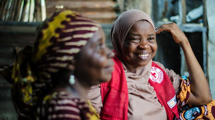 Une femme parle au secrétaire divisionnaire de la Croix-Rouge nigériane de Song, au Nigeria, de sa famille qui a fui le conflit et du nouveau moyen de subsistance qu'elle a mis en place grâce à l'assistance en espèces.
