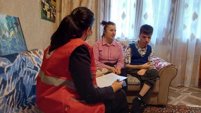 A Red Crescent volunteer meets with Şiriyeva and her son Fuad