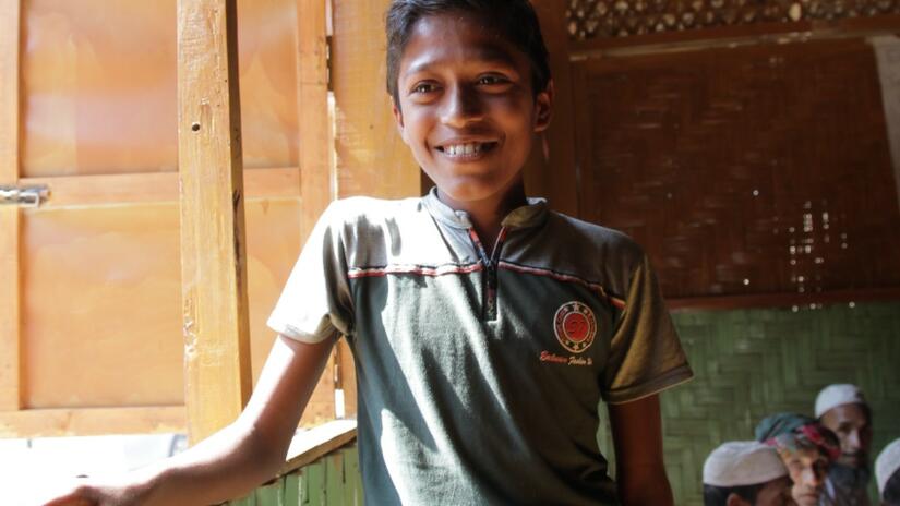 Anwar, a young boy from Myanmar stands in a community safe space run by the Bangladesh Red Crescent Society with support from the Danish Red Cross.