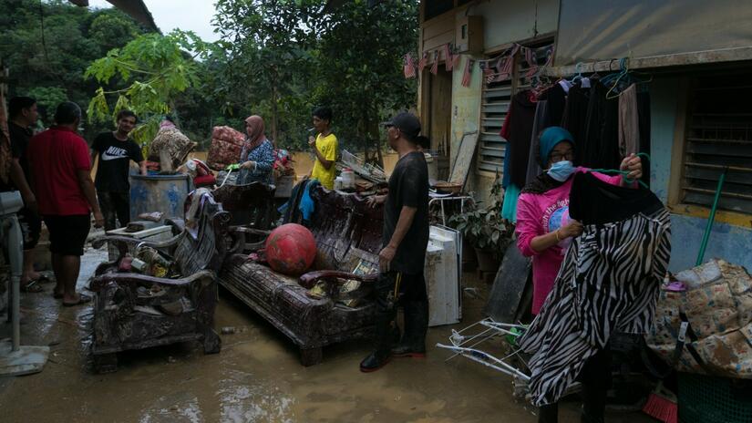 People in Terengganu, Malaysia inspect damage to their possessions after their homes were affected by heaving flooding in summer 2021