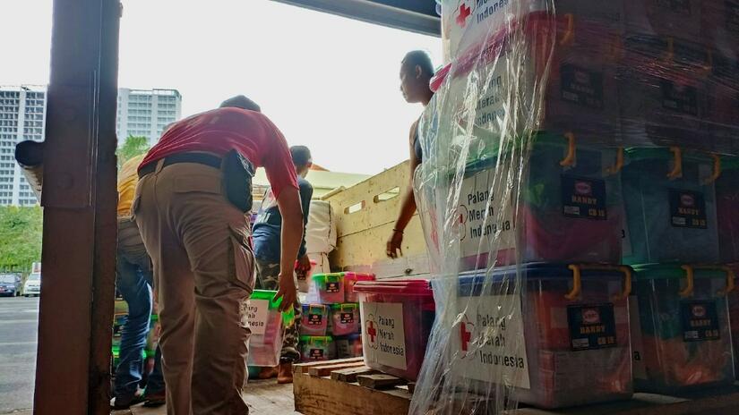 Volunteers from the Indonesian Red Cross (Palang Merah) distribute aid supplies to people affected by the eruptions of Mount Semeru volcano, East Java in early December 2021.