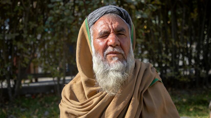 An Afghan man looks on as he waits for volunteers of Afghan Red Crescent to distribute emergency food relief