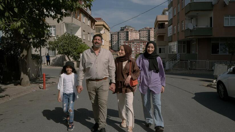Fifteen-year-old Syrian artist, Eslam, and her family walk together in Turkey. They are among the 1.5 million people receiving monthly cash assistance through the Emergency Social Safety Net (ESSN).