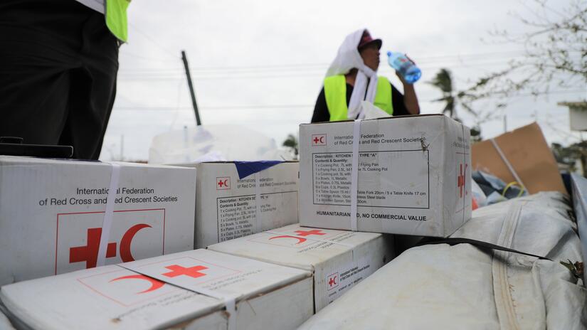 Um voluntário da Cruz Vermelha para para se refrescar no meio da entrega de ajuda às comunidades em Tonga.