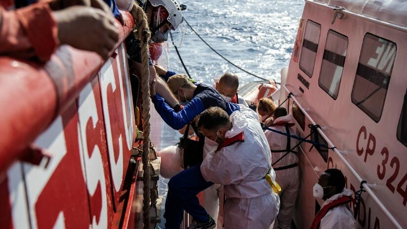 IFRC and SOS MEDITERRANEE crews on board the Ocean Viking search and rescue ship assist six survivors to cross onto an Italian Coast Guard vessel in order to be evacuated for urgent medical treatment in September 2021