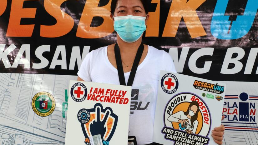 A woman in the Philippines poses for a photo following her second COVID-19 vaccine administered by the Philippine Red Cross in April 2022. The Philippine Red Cross is helping vaccinate the population through 26 vaccination sites and 17 mobile clinics across the country, ensuring even remote communities can get their jab.