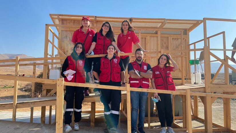 Lebanese Red Cross and IFRC WASH staff stand in front of newly designed latrines, specially built to meet the needs of menstruating women and girls and people with disabilities