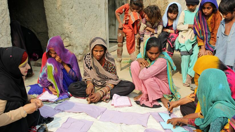 Un groupe de jeunes femmes d'une région rurale du Pakistan participe à une séance de fabrication de serviettes hygiéniques organisée par la Croix-Rouge suisse et l'Université Aga Khan au Pakistan.