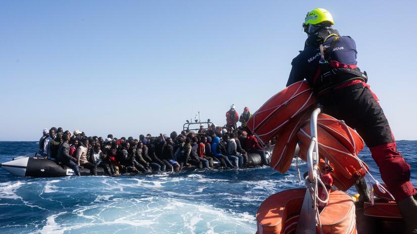 SOS MEDITERRANEE rescue teams approach an overcrowded rubber boat in the Mediterranean in late March 2022. Teams brought people aboard the Ocean Viking ship as part of a 5-hour rescue operation during dangerous weather conditions. Two people had tragically lost their lives aboard the dinghy.