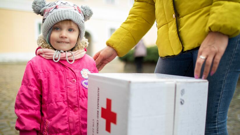 Little Hanna from Kharkiv stands with her mother as they collect a hygiene kit from the Ukrainian Red Cross as they make their way out of Ukraine in late March 2022.
