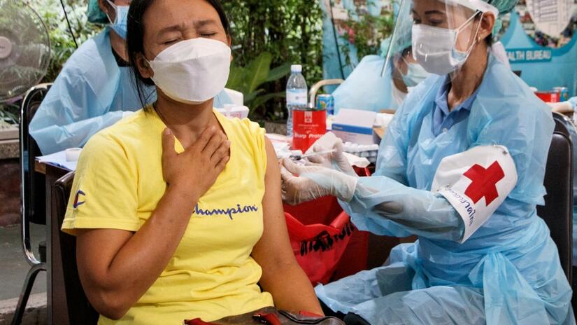 A migrant worker winces as she is injected with the COVID-19 vaccine by a nurse from the Thai Red Cross, Bangkok, Thailand. 16 November 2021