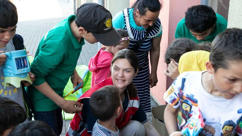 Nataliia, delegada ucraniana de salud mental y apoyo psicosocial de la IFRC, ayuda a los niños que huyen del conflicto en Ucrania a recoger juguetes y otros suministros en un punto de asistencia al otro lado de la frontera en Hungría.