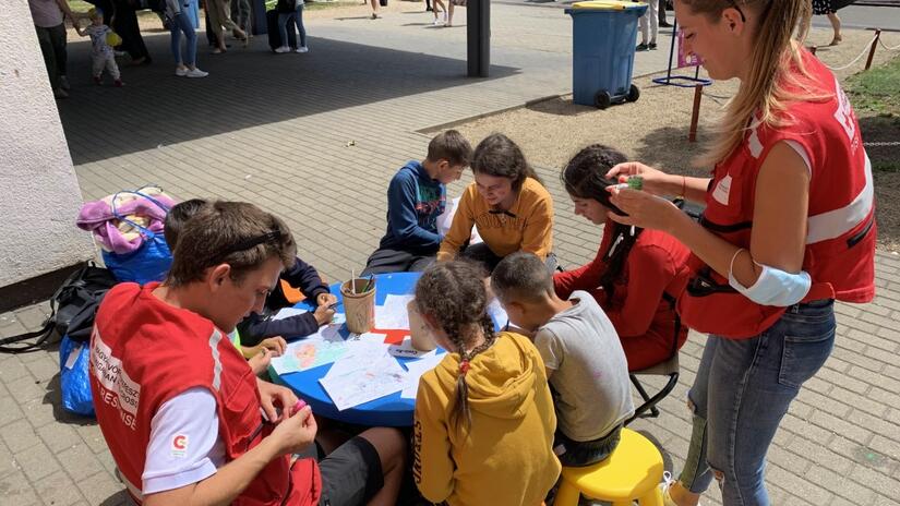 Unas personas voluntarias de la Cruz Roja Húngara en la estación de tren de Záhony, en la frontera con Ucrania, ayudan a los niños afectados por el conflicto a jugar y crear arte juntos. Los juegos y el arte les ayudan a expresar sus sentimientos y a disfrutar de un momento de calma mientras sus familias se plantean la posibilidad de seguir adelante.