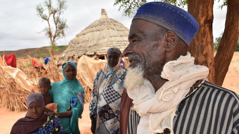 Boubacar Alzouma, un cultivateur de 76 ans, se tient debout avec sa famille devant sa maison dans une banlieue isolée de Niamey en juillet 2022.