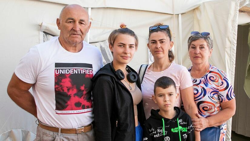 Daryna, a 17-year-old from Donetsk, stands with her family outside the Red Cross health centre in Uzhhorod