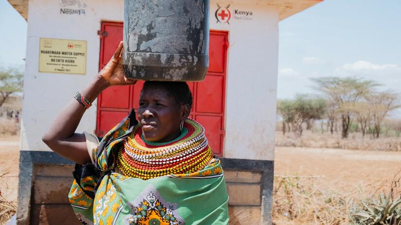 Scolastica Esekon, del condado de Isiolo (Kenia), lleva en la cabeza un cubo de agua limpia que recogió de un pozo excavado por voluntarios de la Cruz Roja Keniana para ayudar a las comunidades a hacer frente a la actual sequía.