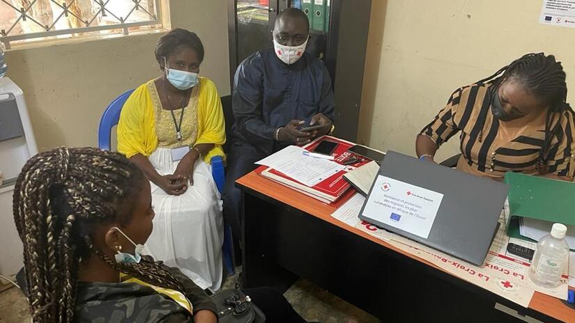Voluntarios de la Cruz Roja Senegalesa escuchan y asesoran a una mujer que se desplaza por Senegal.