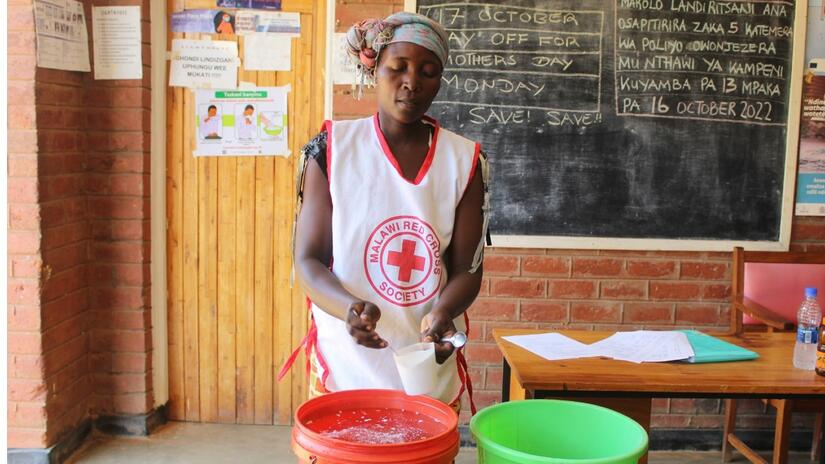 Una voluntaria de la Cruz Roja de Malaui enseña a un grupo de voluntarios sobre la cloración en octubre de 2022, mientras el país lucha contra su peor brote de cólera en dos décadas.