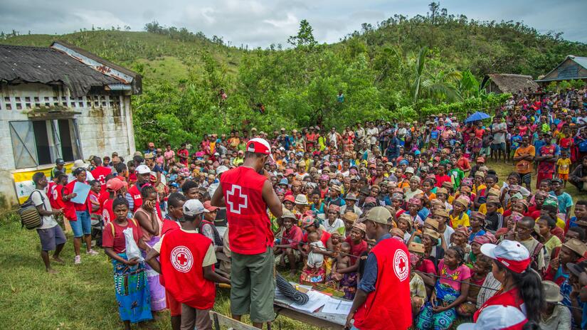 Varias personas voluntarias de la Cruz Roja Malgache hablan con los habitantes de la comuna rural de Sandrohy (Madagascar) sobre la asistencia que prestan tras la devastadora tormenta tropical y el ciclón de principios de 2022.