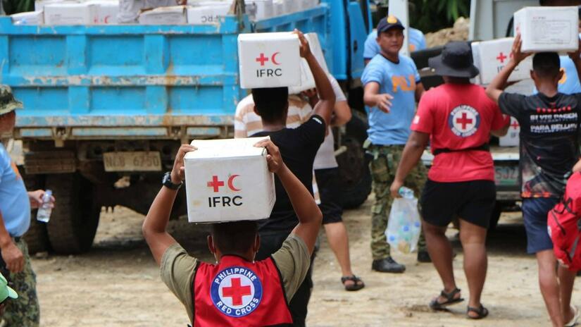 Philippine Red Cross volunteers brave floodwaters and hike challenging terrain to deliver essential supplies to families affected by a 7.0 magnitude earthquake in August 2022.
