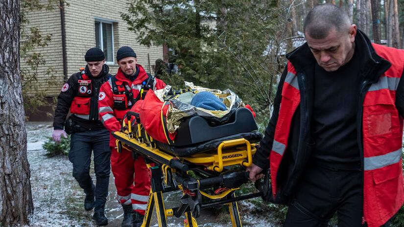 A woman with two broken hips is carried from her home via stretcher to go and receive medical treatment by a Ukrainian Red Cross Emergency Response Unit in January 2023.