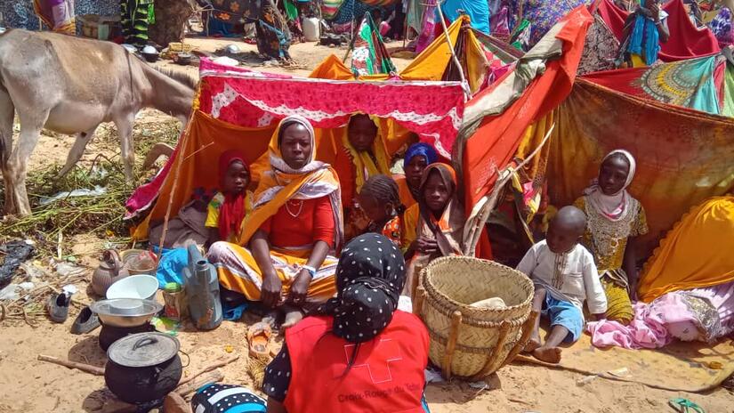 A family who fled conflict in Sudan sit together in a tent across the border in Chad in May 2023 where they receive assistance from the Chad Red Cross.
