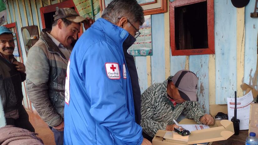 Personal voluntario de la Cruz Roja Colombiana entrega radios y baterías a las comunidades rurales que viven cerca del volcán Nevado del Ruiz, para que puedan mantenerse informadas sobre la actividad volcánica y el riesgo permanente de erupción.