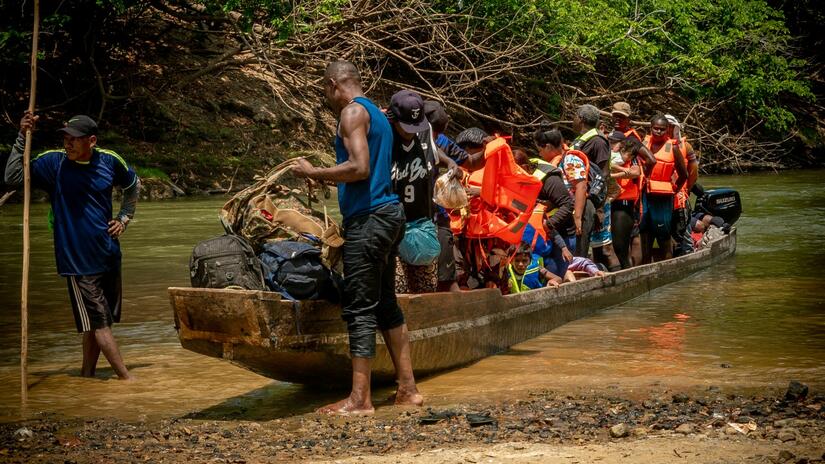 قارب صغير مليء بأشخاص بالغين وأطفال عبروا غابة داريان يصل إلى بنما في مايو/أيار 2023. 