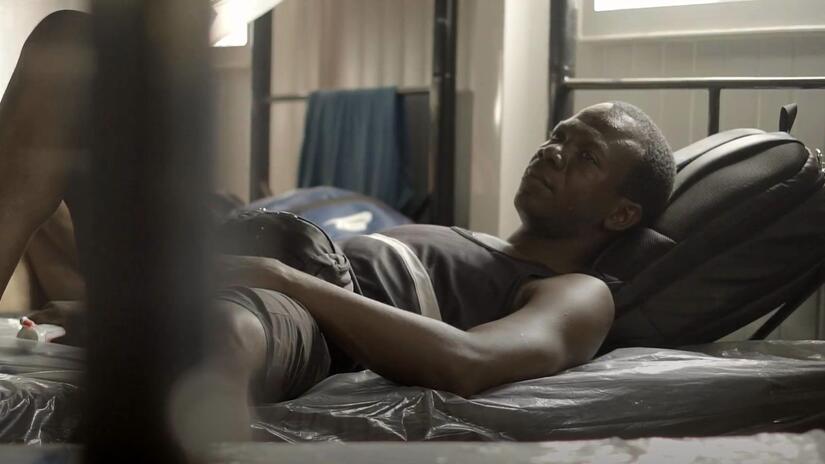 Francis from Sierra Leone lies on a bed in the Panamanian Red Cross reception centre to recover from his gruelling walk through the Darien jungle and plan what to do next.