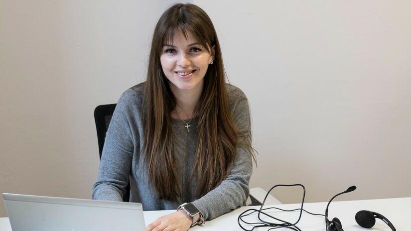 Christina from Kyiv smiles to the camera as she awaits her next call to the Polish Red Cross Infoline, through which she offers psychosocial support to people who have fled Ukraine.