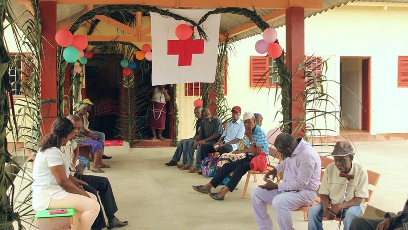 Les résidents du centre pour personnes âgées de São Tomé et Príncipe sont assis devant l'entrée du centre et discutent entre eux, en 2019.