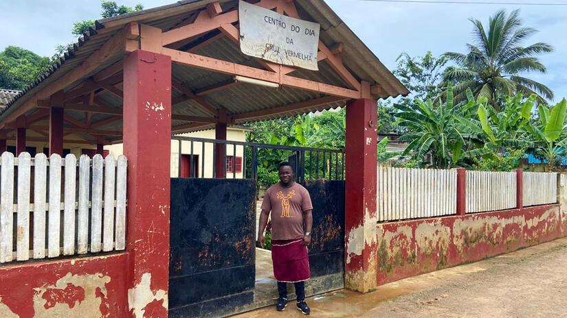 Ronaldo, volontaire de la Croix-Rouge de São Tomé et Príncipe, se tient devant le centre du jour pour personnes âgées, où il travaille volontairement comme gérant et cuisinier.