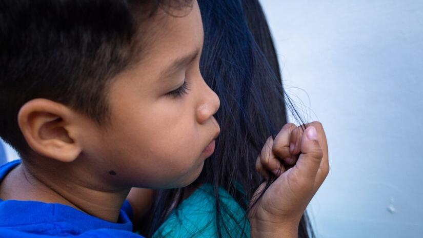 Young Samuel cuddles his mother as they make their way from Venezuela to Medellin, Colombia to seek specialized treatment for his various health issues.