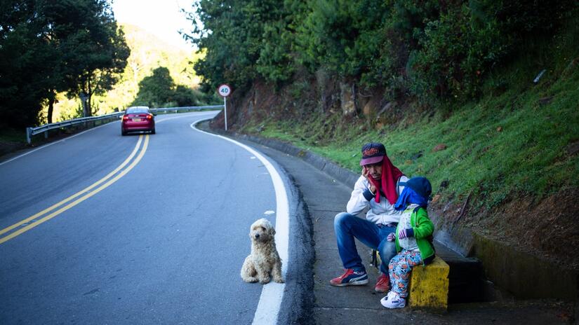 A small dog keeps Juan and his son Santiago company as they try to hitchhike through Colombia on their way to Bogota.