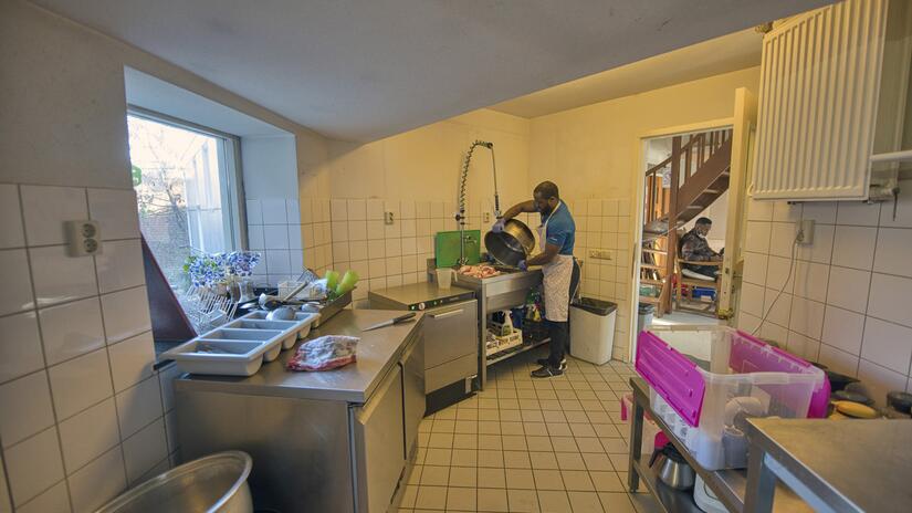 Izzy from Sierra Leone does some food prep at World House in Amsterdam, a place where undocumented migrants can come to get a warm meal.