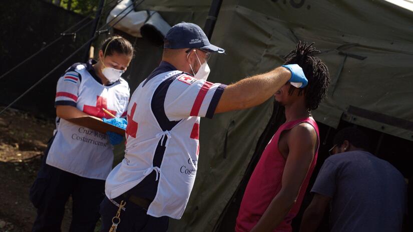 A Costa Rican Red Cross medical team performs a temperature check on a man staying at the migrant centre on the border with Nicaragua to check for signs of COVID-19.