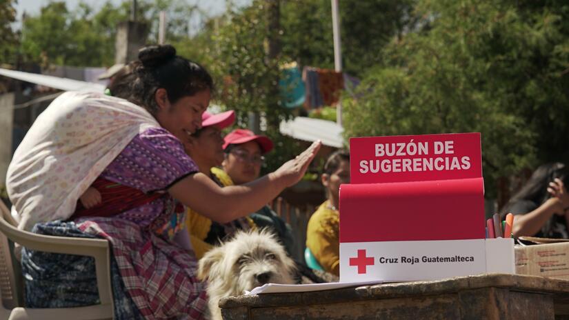 Gladis and a group of women from the local health committee in Xecaracoj stand hold a group meeting and provide suggestions to the Guatemalan Red Cross via a suggestion box.