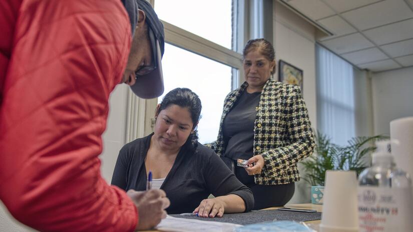 An undocumented migrant from Brazil signs up to receive a supermarket food voucher from the Company of Friends organisation in Amsterdam, provided by the Netherlands Red Cross.