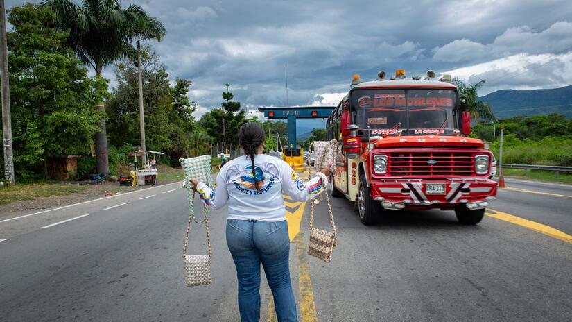 Gabriela Campos from Venezuela sells handbags made of Venezuelan currency on a highway out of Cucuta, Colombia.