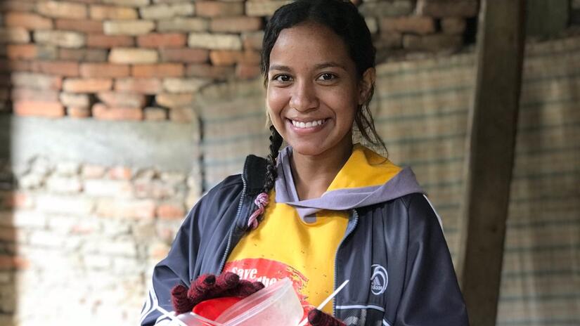 18 year-old Yusmil, who is migrating from Venezuela to Colombia in search of a better life, smiles for the camera.