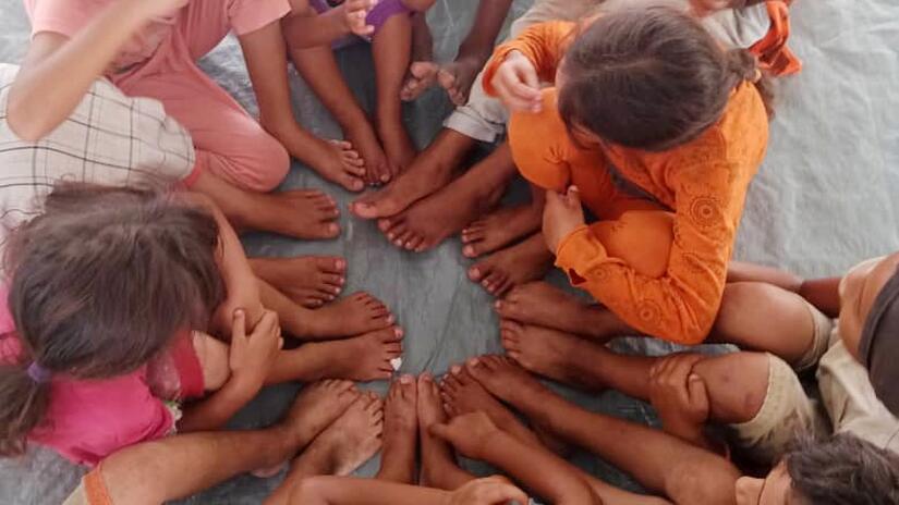 Lia's children sit together with other kids on the floor of a camp for internally displaced persons in Port Sudan .