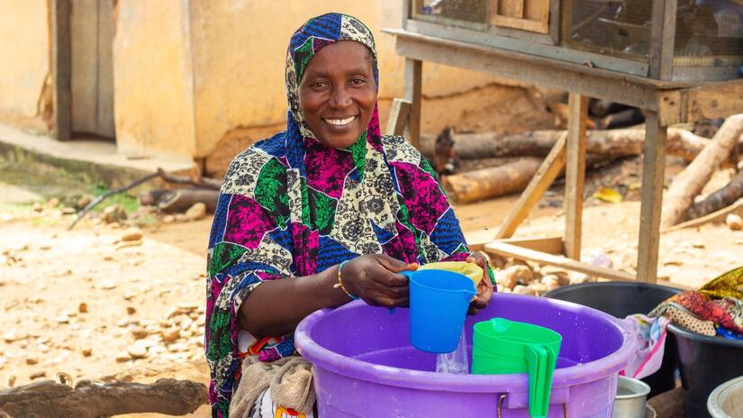 Amina Rasak, d'Obretema, dans l'est du Ghana, a créé son propre petit commerce d'eau avec l'eau qu'elle achète grâce à la nouvelle pompe installée par la Croix-Rouge ghanéenne.