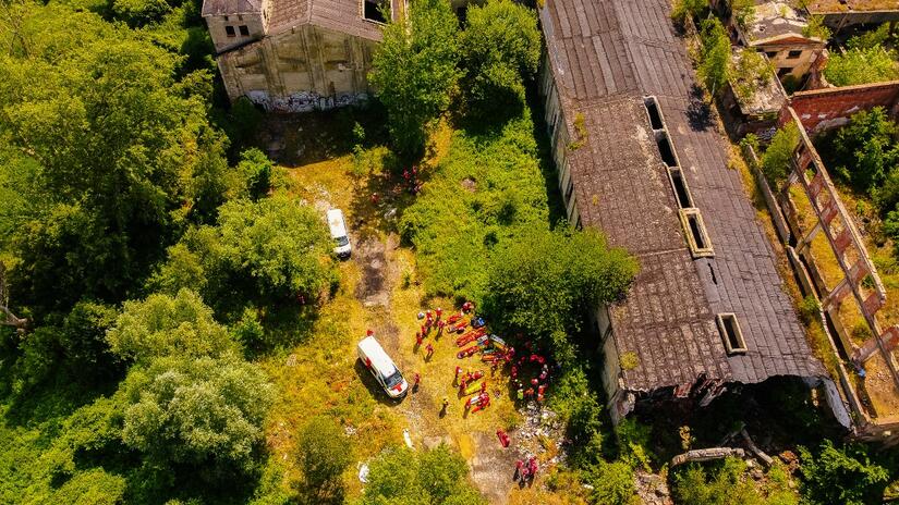 Vista aérea de la fábrica abandonada donde se reúnen personas voluntarias y vehículos de la Cruz Roja mientras se pone en marcha el ejercicio de respuesta a desastres.