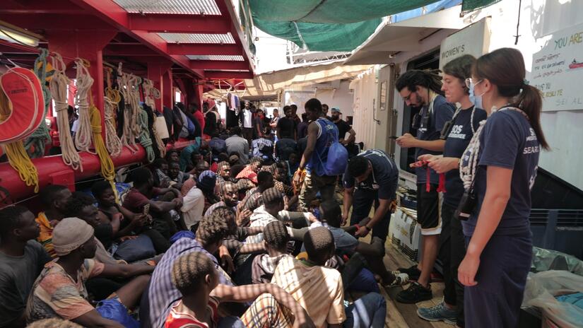 Ahmed and fellow IFRC and SOS Mediterranee crewmembers register and speak to newly-rescued survivors on board the Ocean Viking.