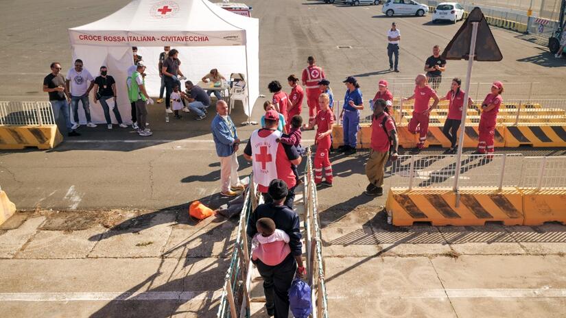 People rescued in the Ocean Viking's largest ever operation disembark in Italy, where they are greeted warmly by Italian Red Cross volunteers who provide additional support to migrants once they're on dry land.